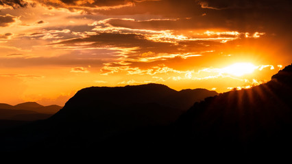 The sun sets behind a mountain in the desert southwest
