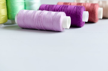 Multi-colored spools of sewing threads close-up. Craft and hobby concept.