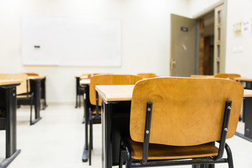 empty classroom with wooden chairs and desks 