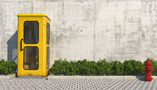 Single old yellow phone booth in retro style on the footpath in the urban exterior opposite the facade of the concrete wall and red fire hydrant. 3D render.