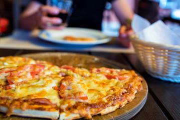 Delicious fresh pizza with tomatoes, salami and melted cheese close