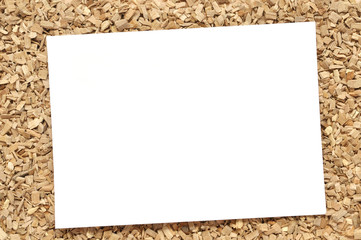 A sheet of white paper on wood chips