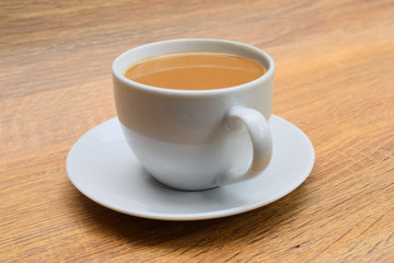  milk coffee in a cup with saucer