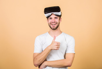 Entertainment and education. Virtual communication. Augmented 3D world. Virtual simulation. Man play game in VR glasses. Explore cyber space. Man hipster virtual reality headset on peach background