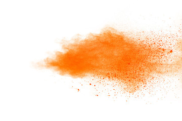 Abstract orange powder explosion. Closeup of orange dust particle splash isolated on white background