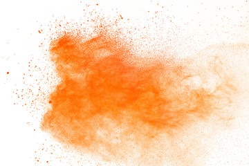 Abstract orange powder explosion. Closeup of orange dust particle splash isolated on white background