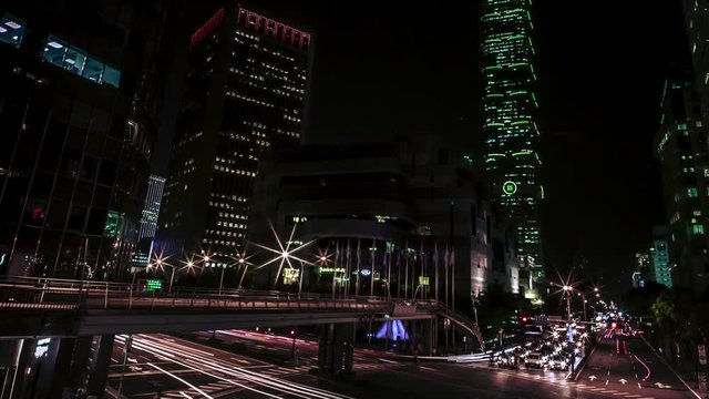 Timelapse overhead view of Taipei main road at night with the famous building 101 and traffic car light long exposure photo shooting technique. Cityscape of street with traffic and pedestrians.-Dan