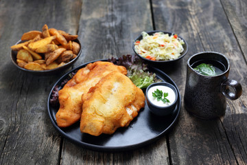 Fried fish in batter with chips and salad.