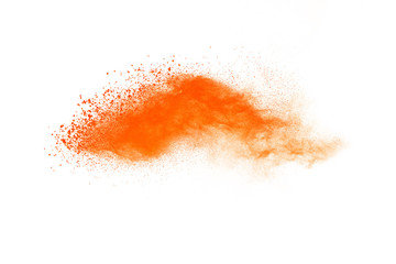 Abstract orange powder explosion. Closeup of orange dust particle splash isolated on white background