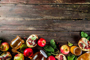 Jewish Autumn Rosh Hashana celebration. Traditional products for the celebration of Rosh Hashanah - apples with leaves, pomegranate, honey, honeycombs, wooden background