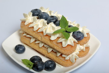 Cakes made from Italian savoyardi cookies and cream. Decorated with blueberries and mint leaves.