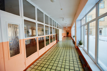 View inside the entrance  corridor , old school or apartment building, dead end long and narrow walkway and glass window with early morning orange shine.