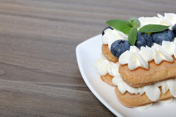 Cakes made from Italian savoyardi cookies and cream. Decorated with blueberries and mint leaves.