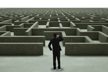 Businessman going straight ahead on a wide road between mazes