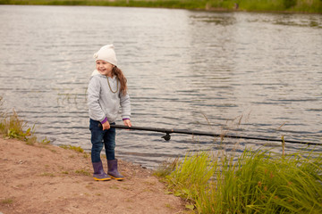 Cheerful girl fishing at the lake