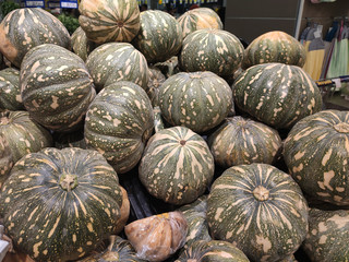 Pile of ripe pumpkin collected and displayed on the rack inside the huge supermarkets for sale. 