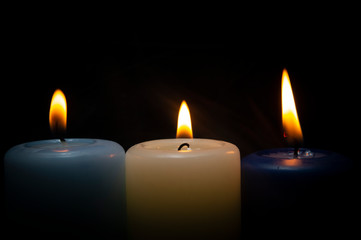 Close up of three colorful wax candles flame