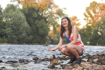 Beautiful middle aged woman on river coast. Older woman enjoy by the river at sunset