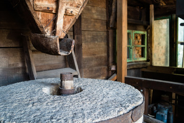 The ancient old stone grain mill gristmill grinding wheat or grains into flour using millstone...