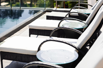 sun beds near swimming pool on resort during daytime