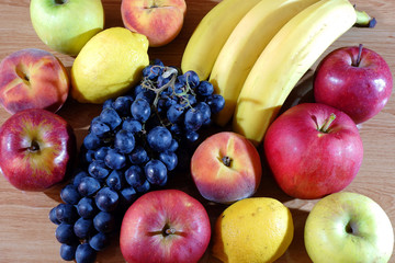 Fresh juicy fruits on a wooden table top view