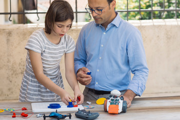 Father teaching his daughter electronics and robotics