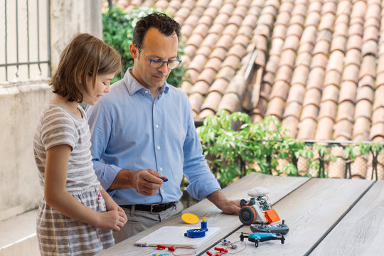 Father teaching his daughter electronics and robotics