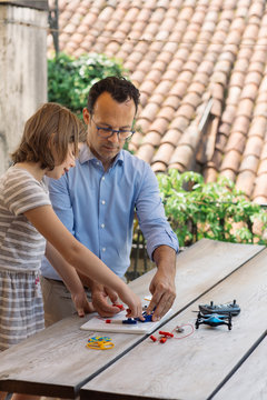 Father teaching his daughter electronics and robotics