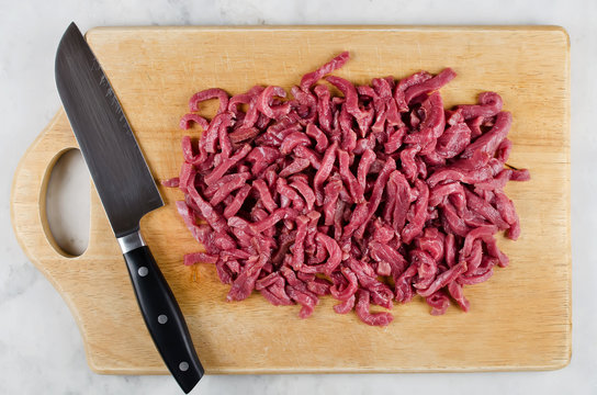 Meat for cooking stir fry on cutting board