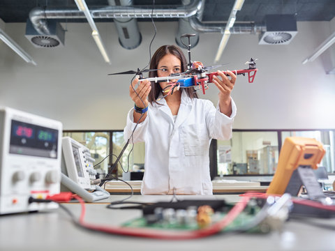 Female technician working in research laboratory, holding drone