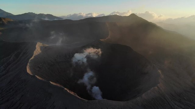 Cinematic aerial view video clip of the crater of mount Bromo at sunrise in the morning, a very popular tourist destination located in East Java, Indonesia.