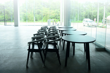 The empty  showroom after renovate with wooden chairs and tables with white bright light from outside