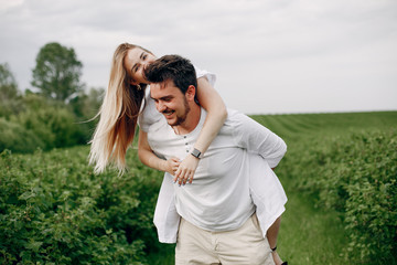 Couple in a field. Blonde in a white dress. Man in a white shirt