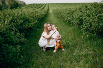 Fototapeta premium Family in a summer park. Mother in a white dress. Cute little boy