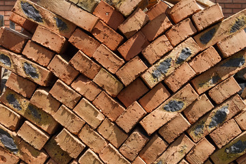Red brick on the pallet on a construction site on a sunny day. Texture. Close up