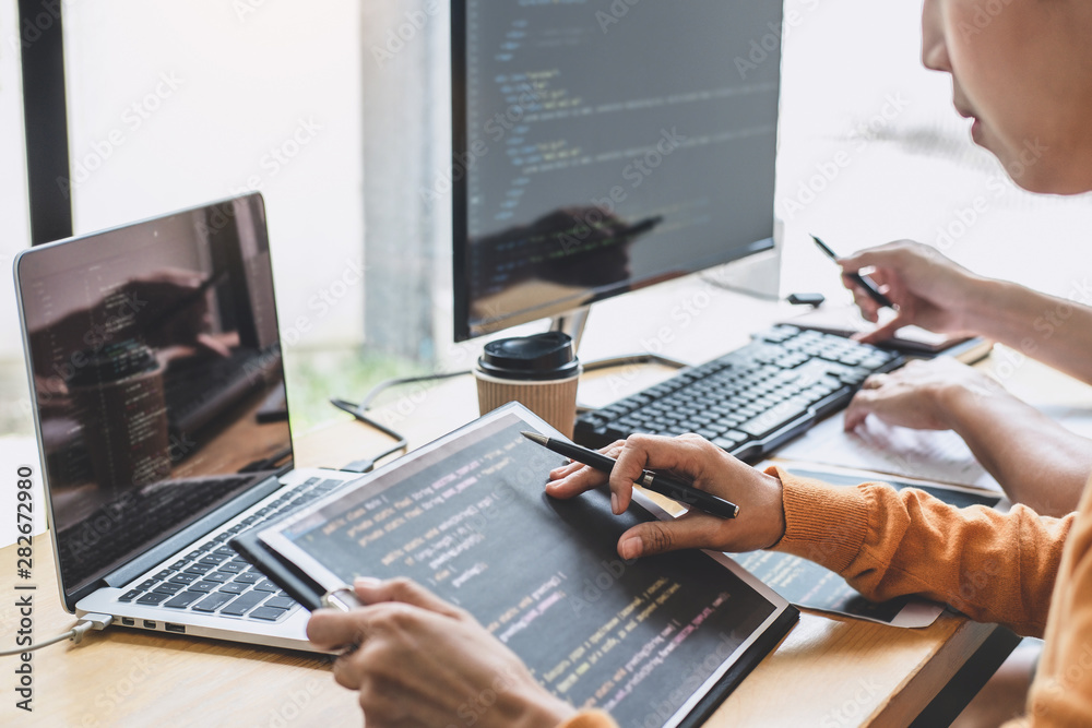Fototapete programmers cooperating at developing programming and website working in a software develop company 