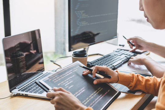 Programmers cooperating at Developing programming and website working in a software develop company office, writing codes and typing data code, Programming with HTML, PHP and javascript