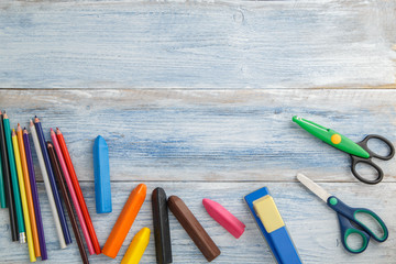 school children's concept. colored pencils,stapler and scissors on a blue and white scuffed vintage...