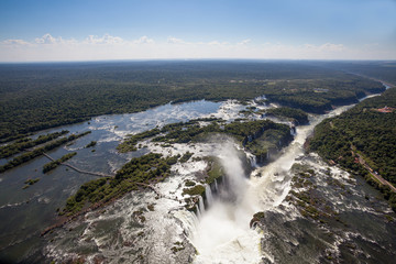 Aerial view of forest and waterfalls in Iguazu river in sunny summer day. Foz de iguaçu divides the border between Brazil and Argentina and is One of the Seven Wonders of the World.
