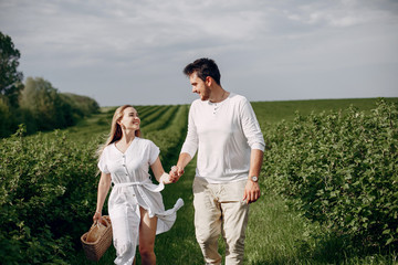 Couple in a field. Blonde in a white dress. Man in a white shirt