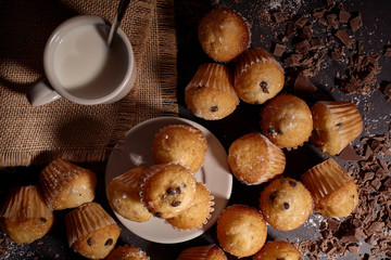 group of muffins next to a cup of milk