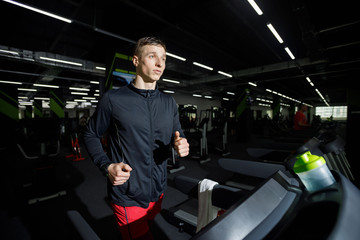 Fototapeta na wymiar Jogger wearing sportswear running on treadmill at gym