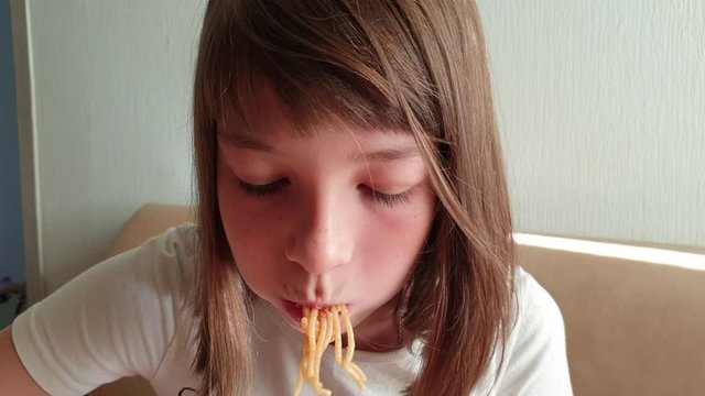 girl eating spaghetti with tomato sauce