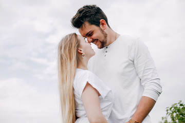 Fototapeta premium Couple in a field. Blonde in a white dress. Man in a white shirt