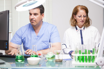 Middle age female scientist working with her assistant in a factory laborator