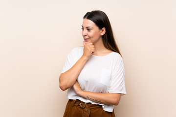 Young brunette woman over isolated background looking to the side