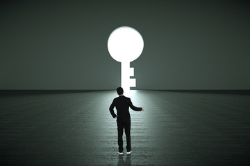Obraz premium Businessman standing alone in front of a big keyhole