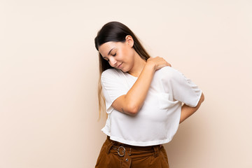 Young brunette woman over isolated background suffering from pain in shoulder for having made an...