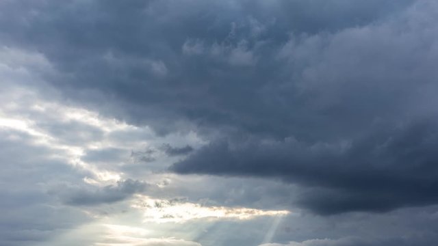 Great dramatic time lapse of sunset sun rays transparemting through huge heavy grey clouds during sunset time. Charming video skyscape in 4k. 