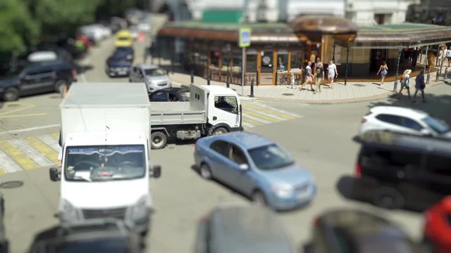People cross the road on a pedestrian zebra, cars let people through .. time laps tilt shift 4k